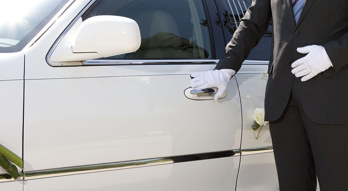 Chauffeur in white gloves opening the car door
