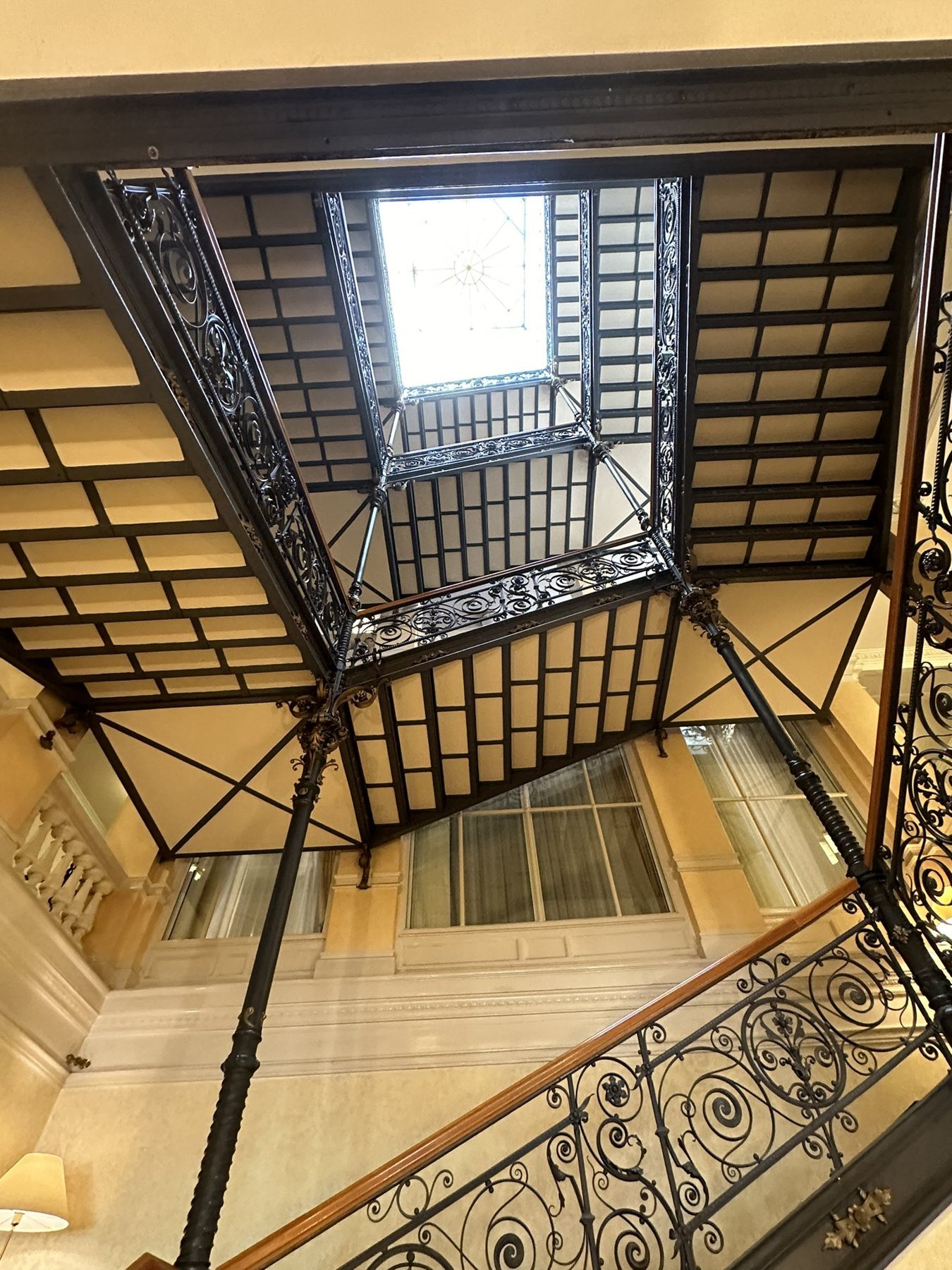 Historic staircase with wrought-iron banister and skylight at Hotel THE FLORIS in Baden-Baden